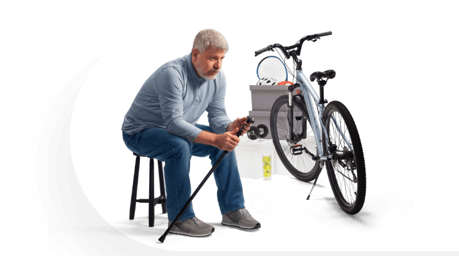Image of a man with a cane sitting down next to a bike and storage containers